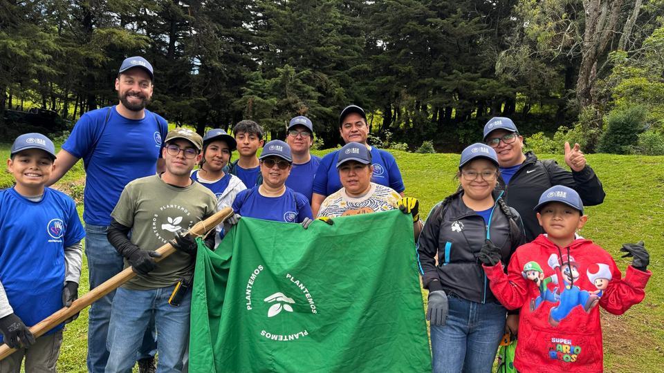 Voluntarios de Plantemos con la bandera de la organización al terminar una jornada